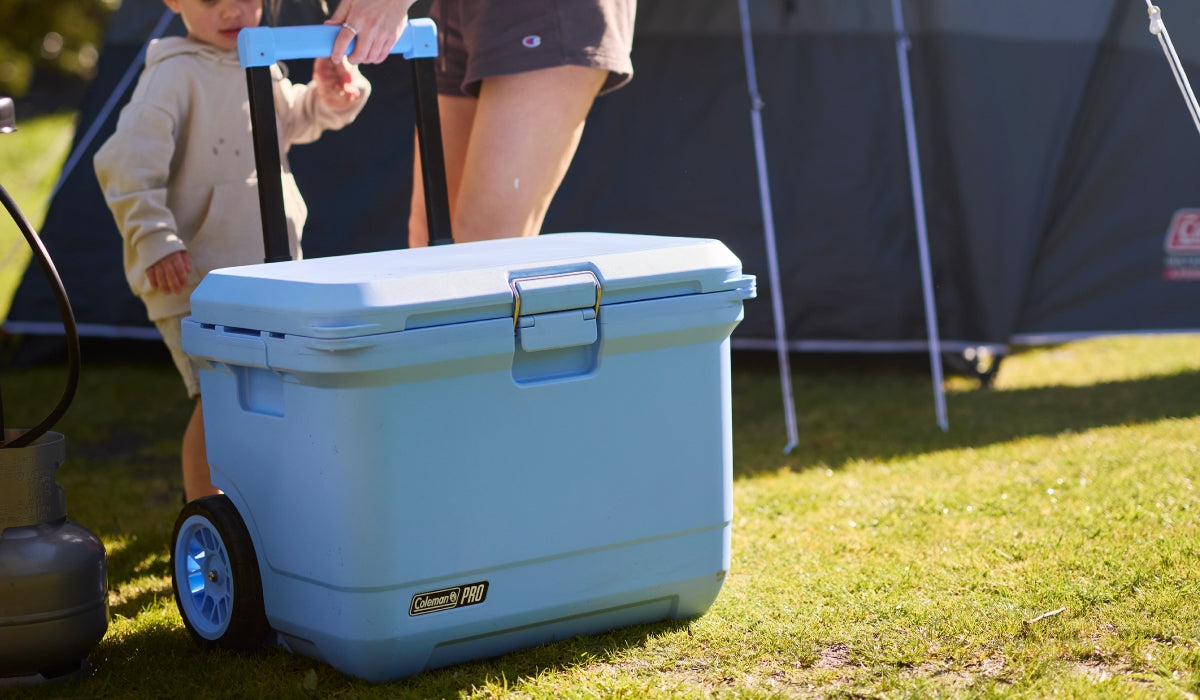 Pro Wheeled Cooler on Grass being pulled my mother and son.